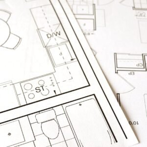 Close-up view of an architectural floor plan on paper showcasing detailed room layouts and measurements.
